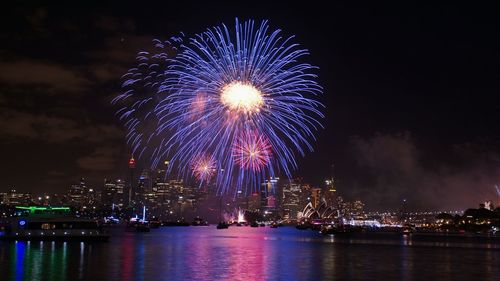 Fireworks display over river at night