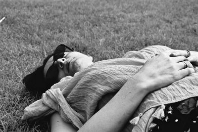 Close-up of hands sleeping on field