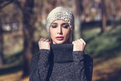 Close-up of young woman with eyes closed standing at park