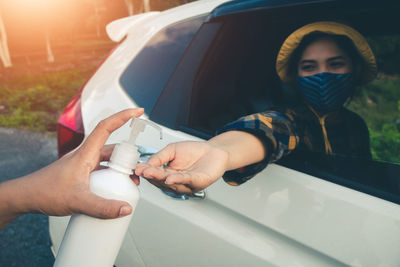 Midsection of woman holding camera while sitting in car