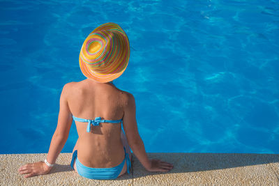 Rear view of woman in bikini swimming pool