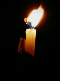 Close-up of lit candle in dark room