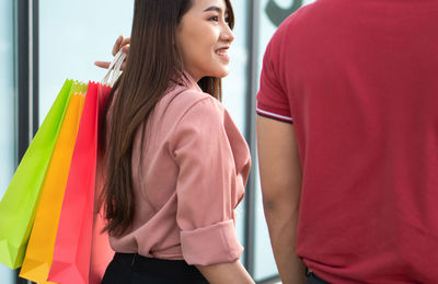 Side view of young woman standing at home