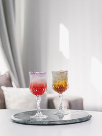 Close up of luxury iced summer drinks rose and orange on white and green marble background