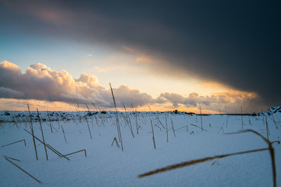 Scenic view of snow covered landscape against sky during sunset