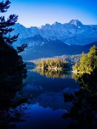 Scenic view of lake and mountains against blue sky