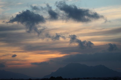 Low angle view of silhouette mountain against dramatic sky