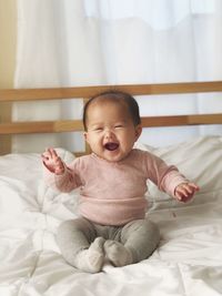 Happy cute baby girl lying on bed