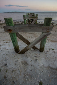 Deck chairs on beach against sky