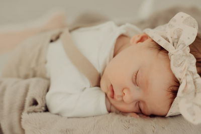 Cute baby girl sleeping on bed at home