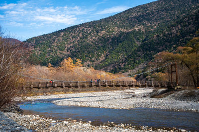 Bridge over river against mountain