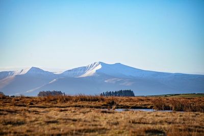 Scenic view of snowcapped mountains against clear blue sky