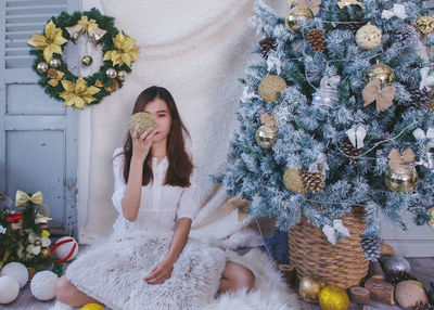 Portrait of young woman with christmas tree