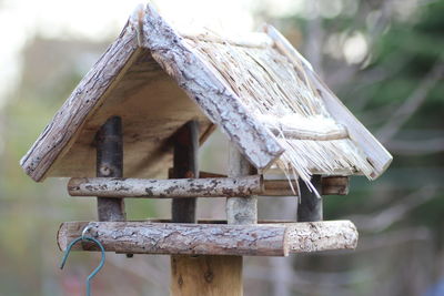 Close-up of birdhouse on roof against house