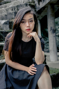 Portrait of young woman sitting outdoors