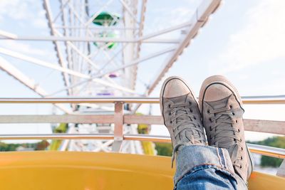 Low section of person wearing canvas shoe on ferris wheel