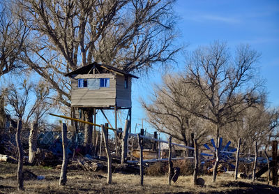 Built structure on field by trees against sky