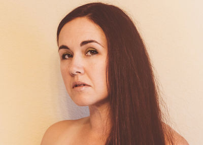 Close-up portrait of woman against wall