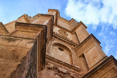 Low angle view of historical building against cloudy sky