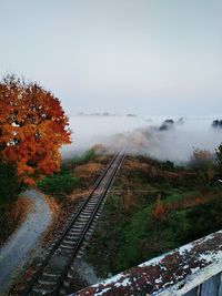 Railroad tracks during foggy weather against sky