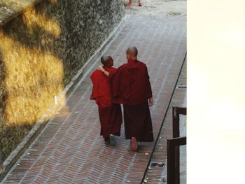 Rear view of people walking on footpath