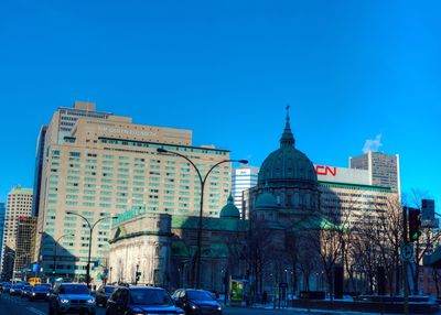 Buildings in city against blue sky