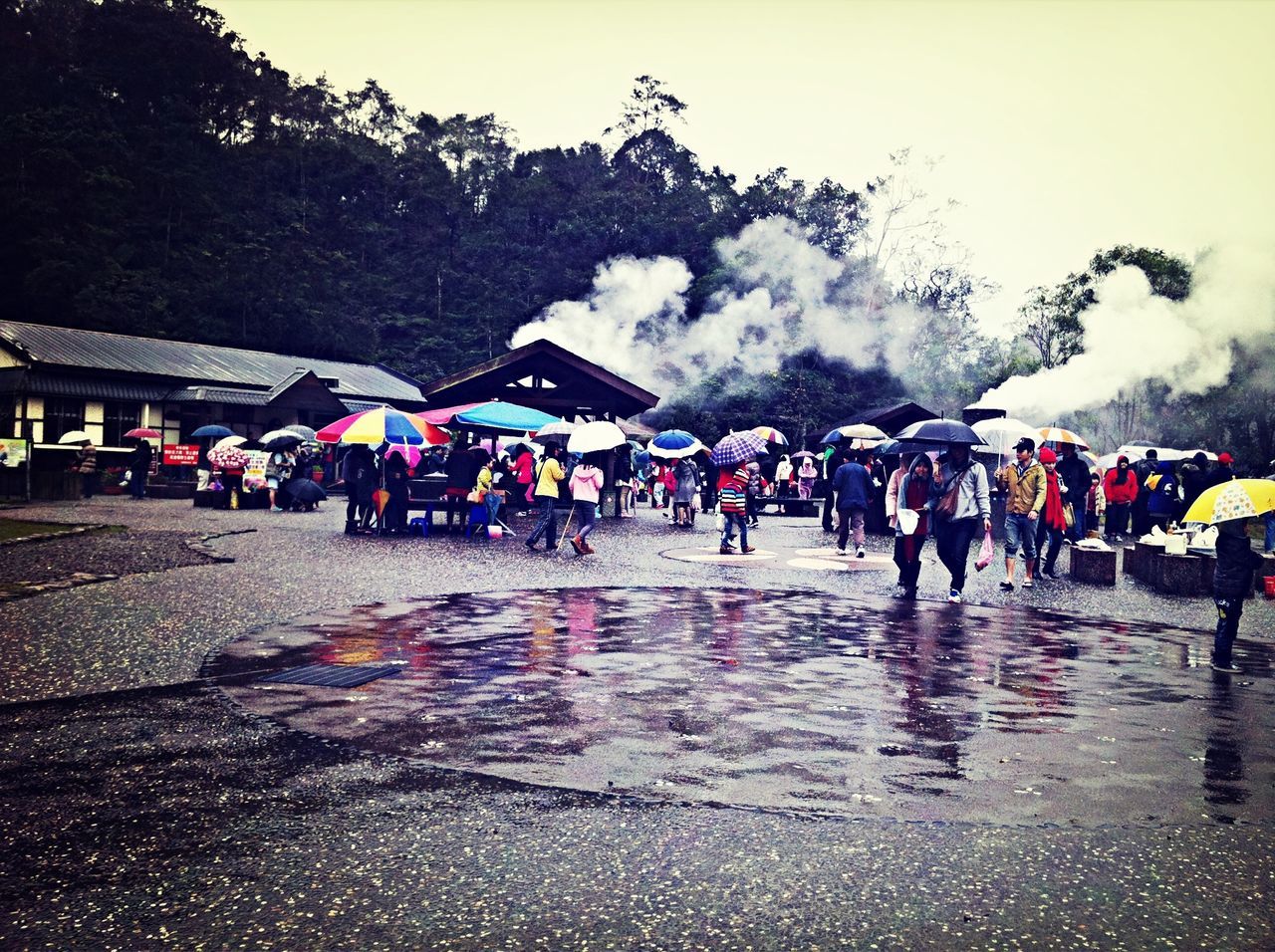 large group of people, person, men, lifestyles, walking, leisure activity, mixed age range, street, water, sky, road, mountain, medium group of people, transportation, tourist, weather, day, tree, rain