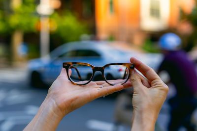 Close-up of human hand holding sunglasses