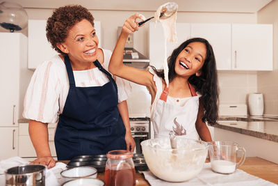 Portrait of smiling friends with food at home