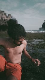 Man looking at sea shore against sky