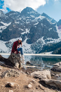 Rear view of woman sitting on snowcapped mountain