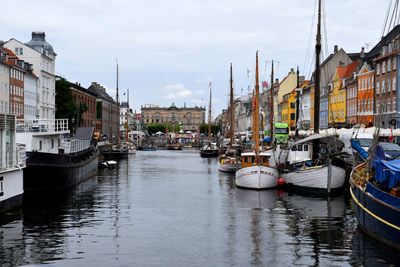 Boats moored at harbor in city