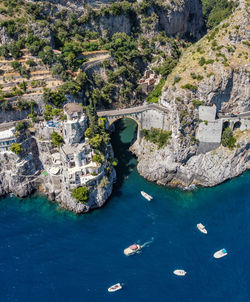 High angle view of boats in sea and fiordo di furore bridge on the amalfi coast, campania, italy