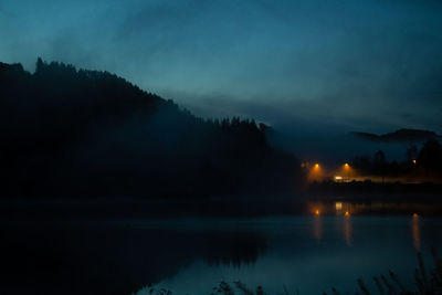 Scenic view of lake against sky at night