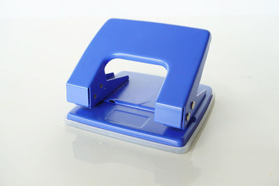 Close-up of blue hole puncher on white background