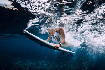 Rear view of woman swimming in sea