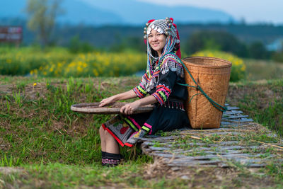 Woman sitting on grass in field