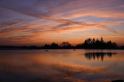 Scenic view of lake against orange sky