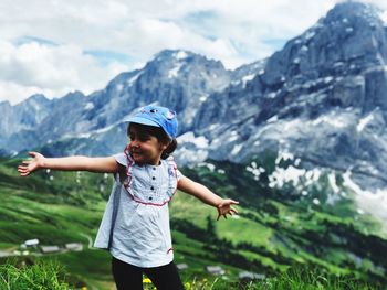 Cute girl with arms outstretched standing on mountain