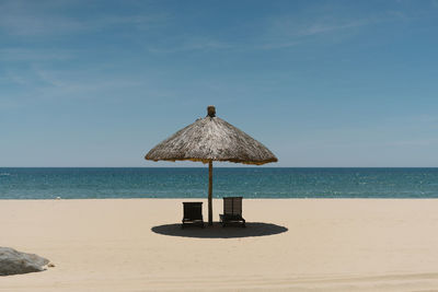 Lifeguard hut on beach against sky