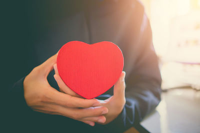 Close-up of woman holding red heart shape