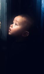 Close-up portrait of boy looking away at window