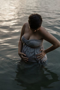 Woman with arms raised in lake