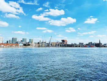 Scenic view of sea by buildings against sky