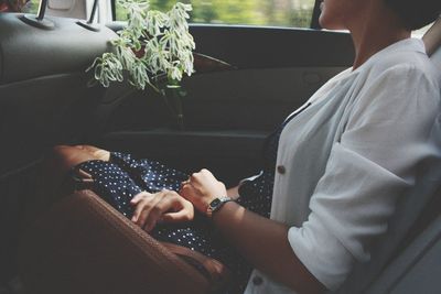 Midsection of woman sitting in car