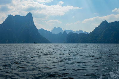 Scenic view of sea and mountains against sky