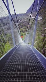 Suspension footbridge against mountains and sky