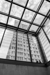 Low angle view of tower seen through glass building