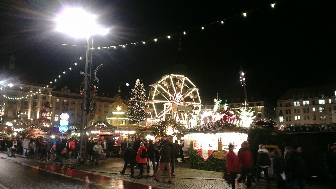 illuminated, night, large group of people, lifestyles, arts culture and entertainment, person, men, street light, leisure activity, built structure, sky, architecture, amusement park, lighting equipment, street, building exterior, city, amusement park ride, city life