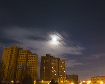 Illuminated cityscape against sky at night